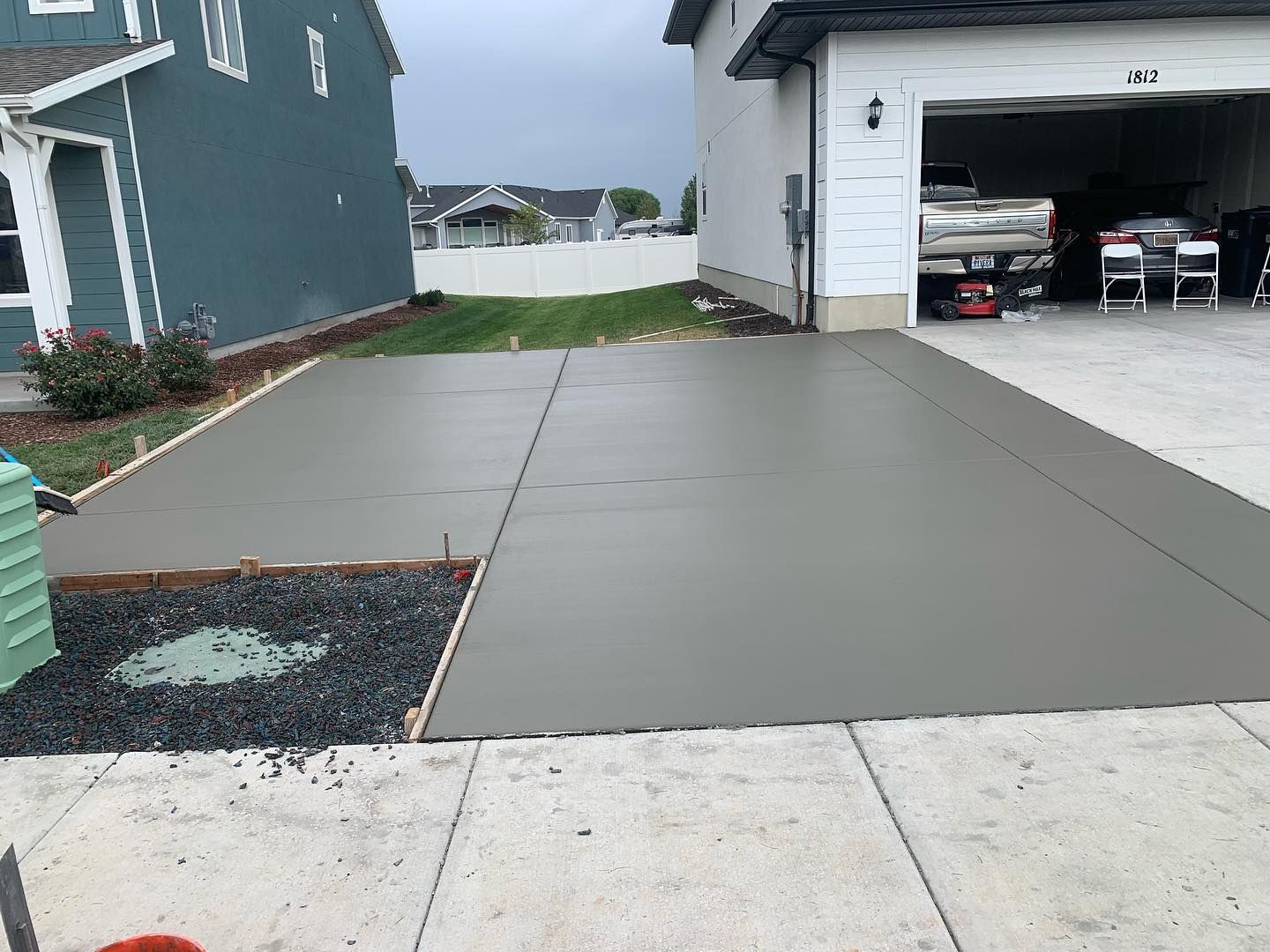 A concrete driveway is being built in front of a house.