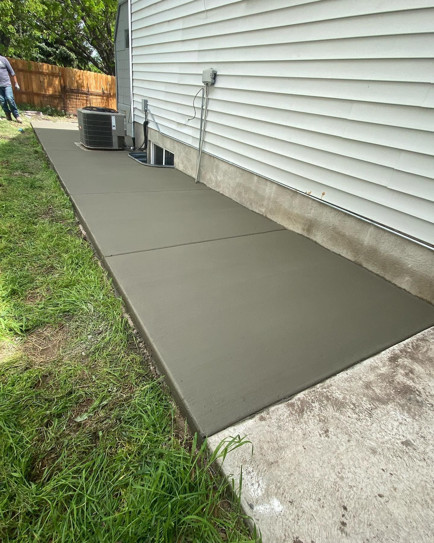 A concrete walkway is being built in front of a house.