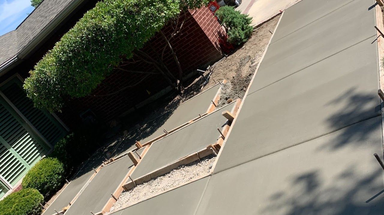 A concrete driveway is being built in front of a house.