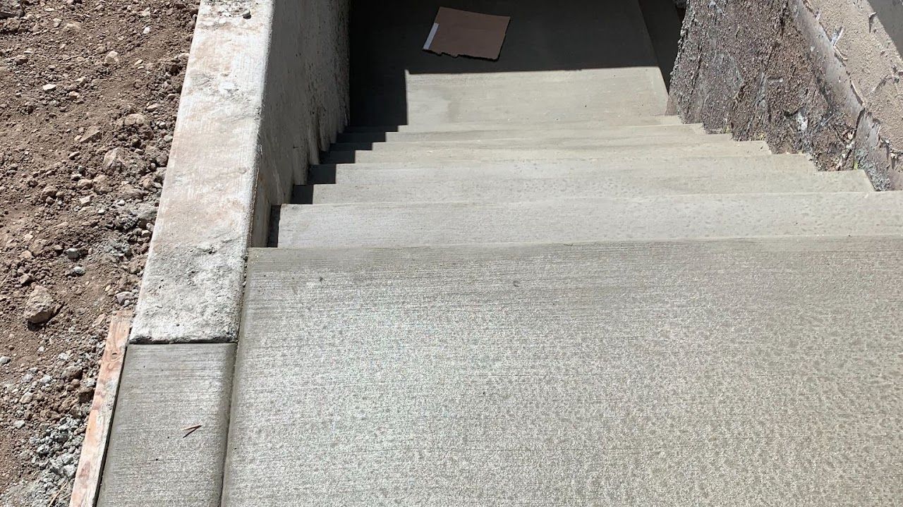 A set of concrete stairs leading up to a building under construction.