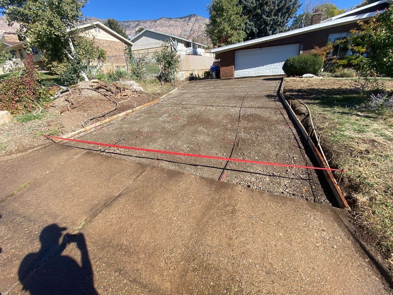 A person is measuring a driveway with a red tape.
