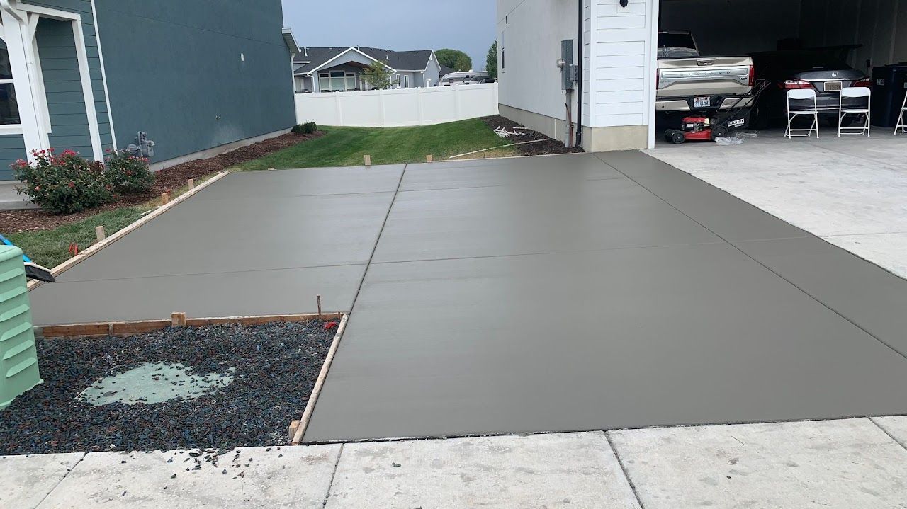 A concrete driveway is being built in front of a house.