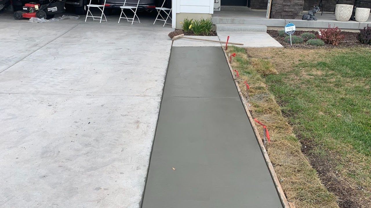 A concrete walkway is being built in front of a house.