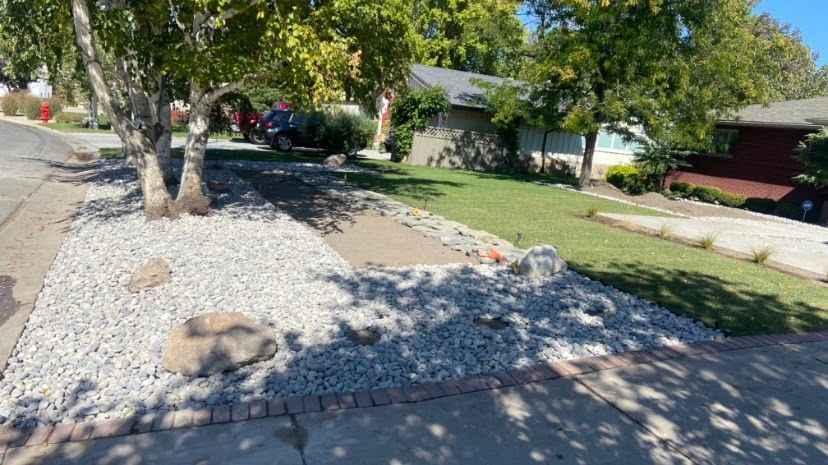 A house with a lot of rocks and gravel in front of it.