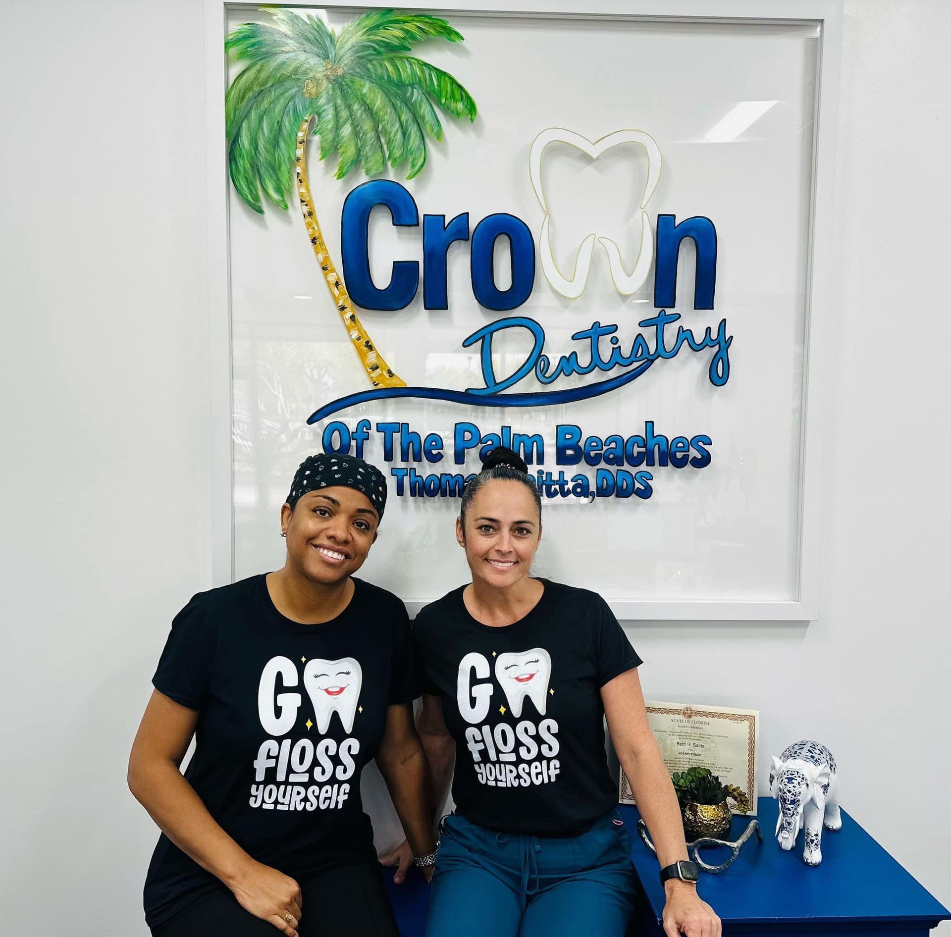 Two women in black t-shirts with tooth design in front of