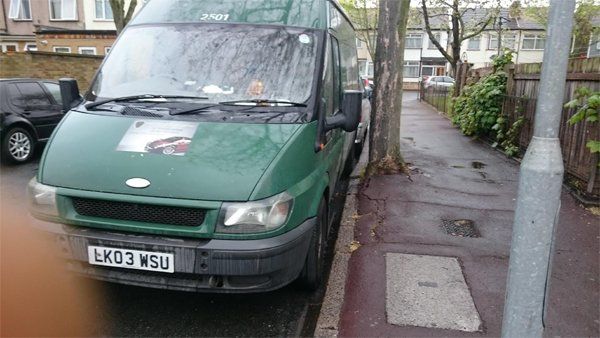 A green van that has been repaired on the side of the road