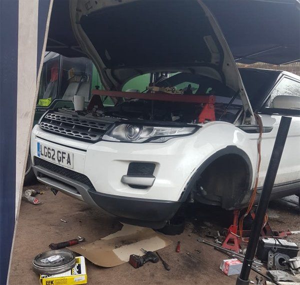 Picture of a range rover with its bonnet open while it is being fixed