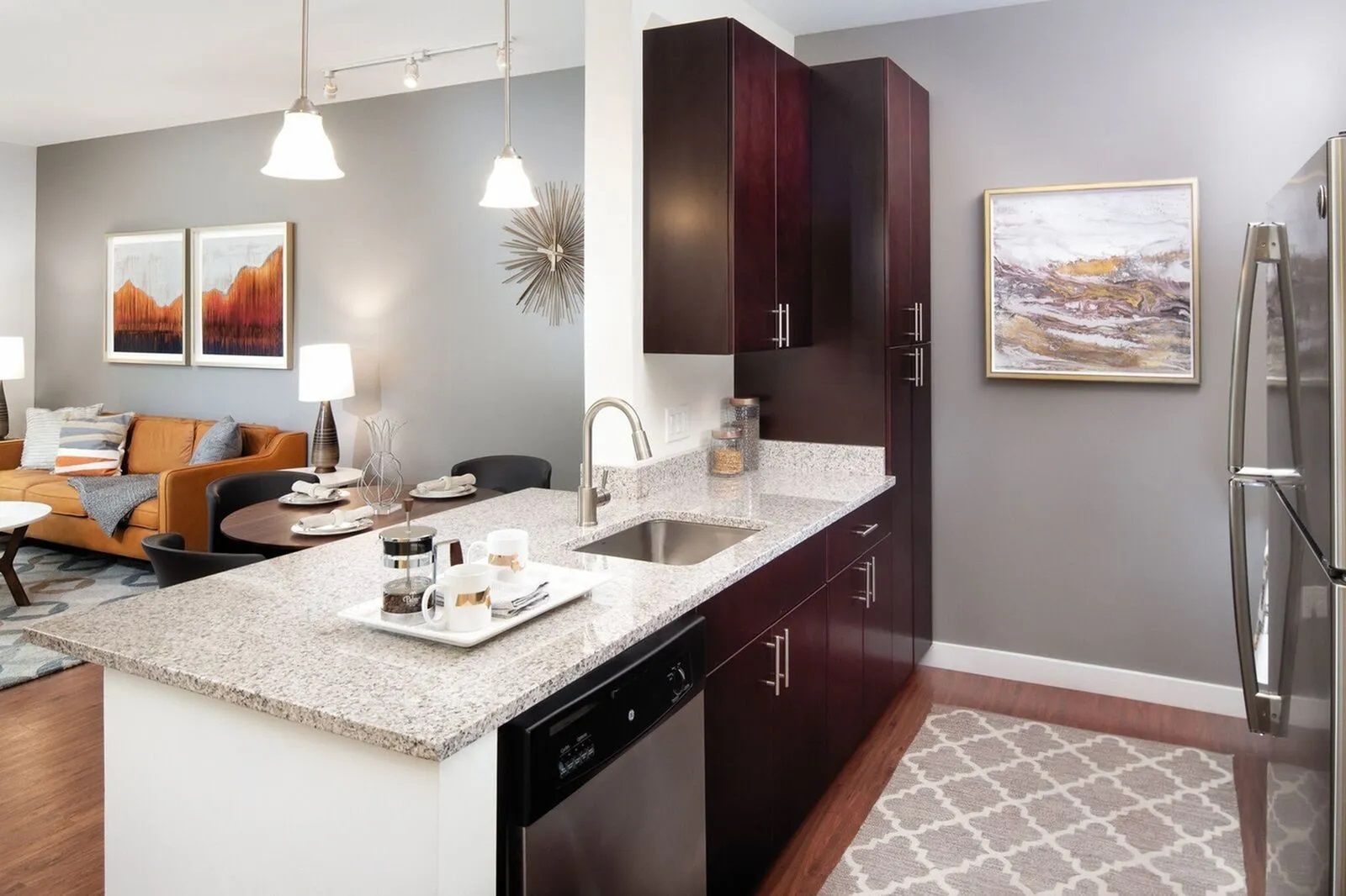 The Residences at Great Pond modern kitchen with dark brown kitchen cabinets and oversized breakfast bar. 