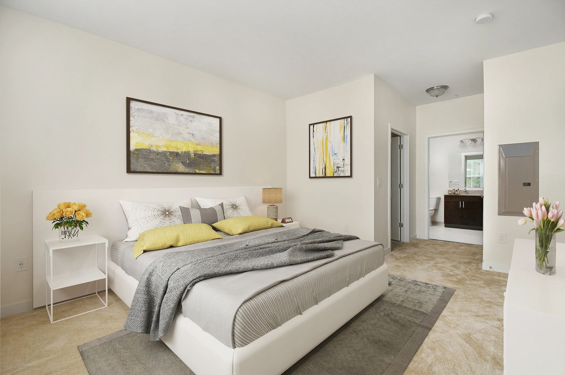 The Residences at Great Pond's apartment bedroom with a bed, rug, wall art, and side tables. 
