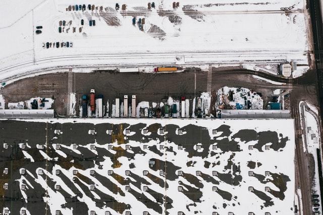 An aerial view of a parking lot covered in snow