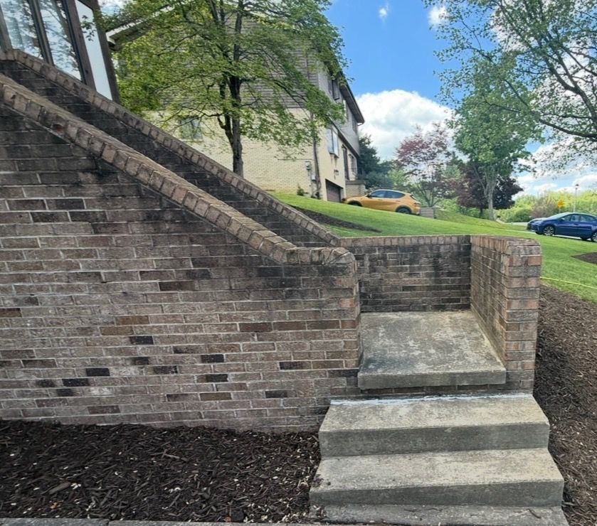 stained brick staircase wall before pressure washing