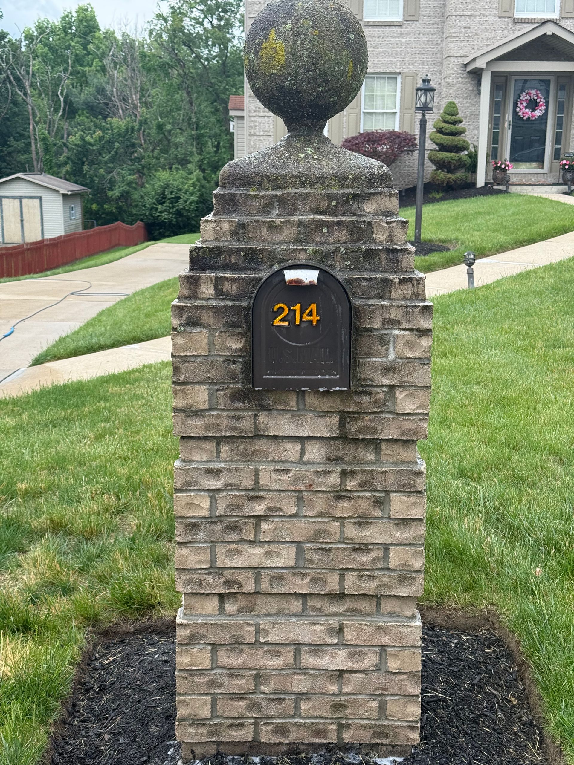 Brick mailbox pillar before pressure washing