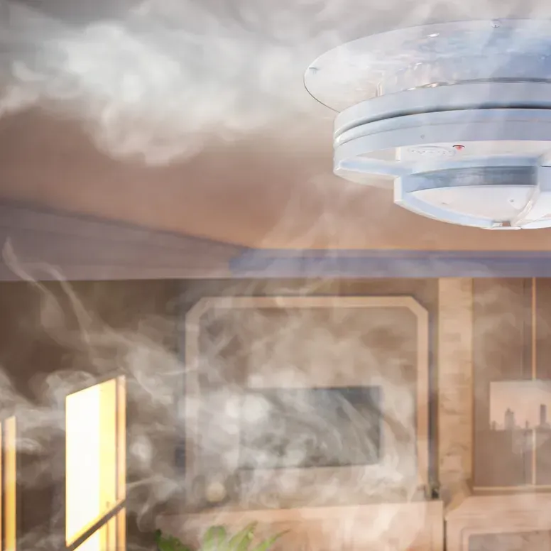 A room filled with thick smoke, with a ceiling light fixture visible at the top.