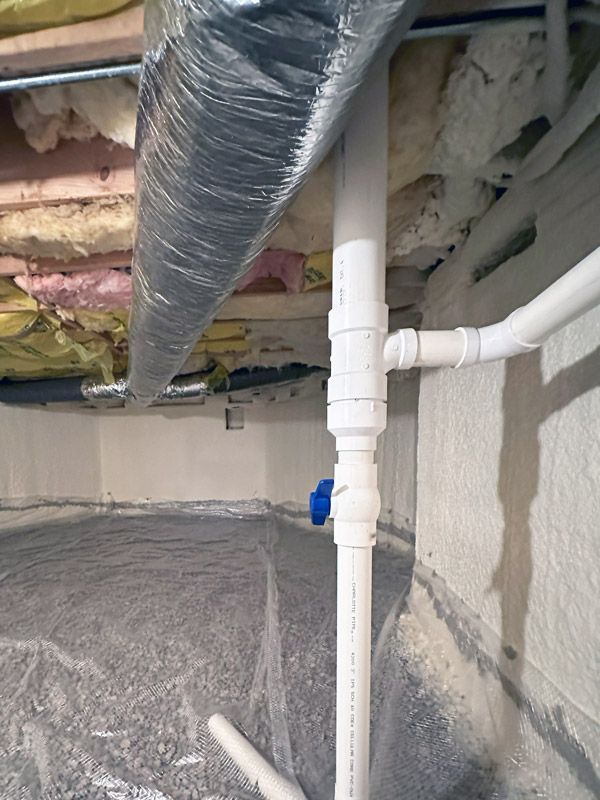 A white pipe is sitting in the middle of a basement.