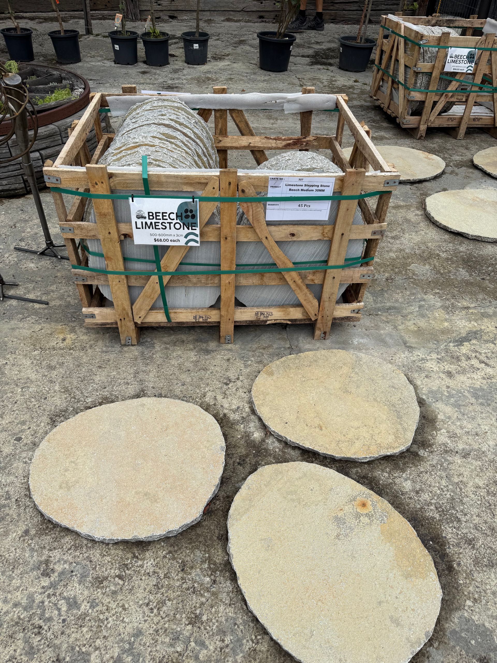 Wooden crate with large stones and several flat stepping stones on concrete ground  — Schutz Landscape and Garden Supplies in Tomerong, NSW