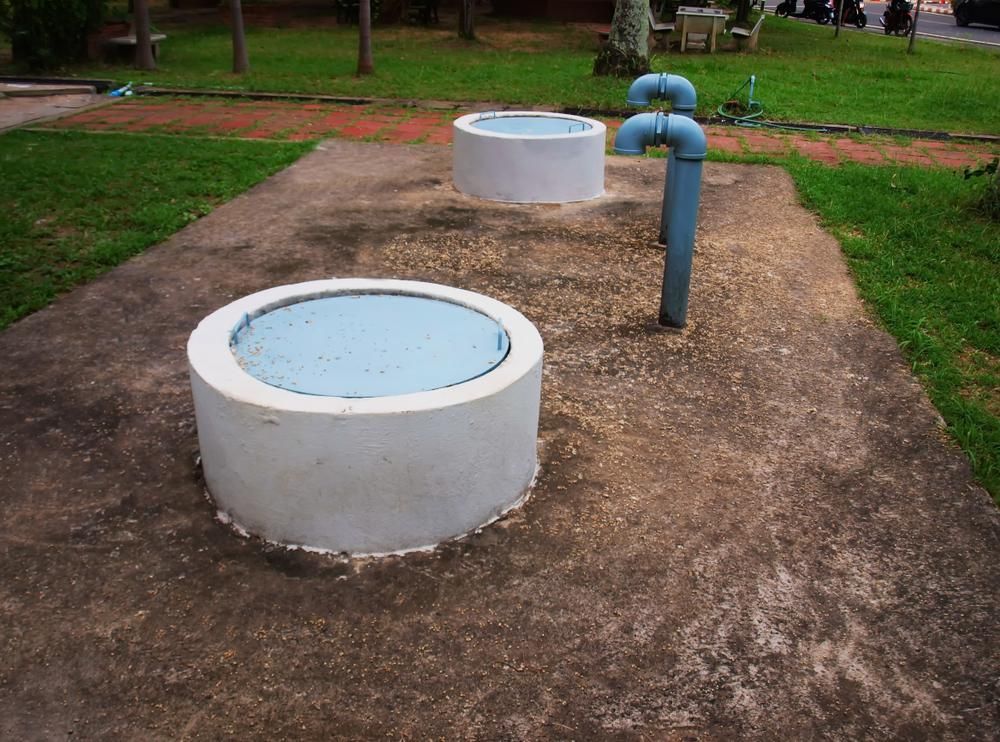 A Concrete Circle With A Blue Lid On Top Of It — Gympie Septic Pump Outs In Banks Pocket, QLD