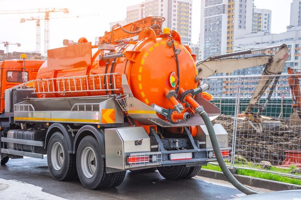 Water Is Being Pumped From A Orange Vac Truck — Gympie Septic Pump Outs In Banks Pocket, QLD