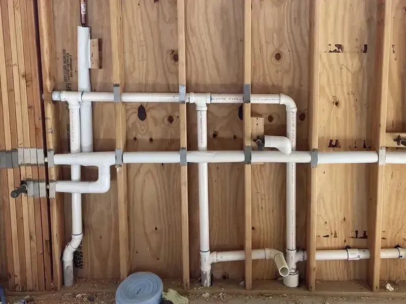 Two gray commercial-style water heaters standing side-by-side in a storage area.
