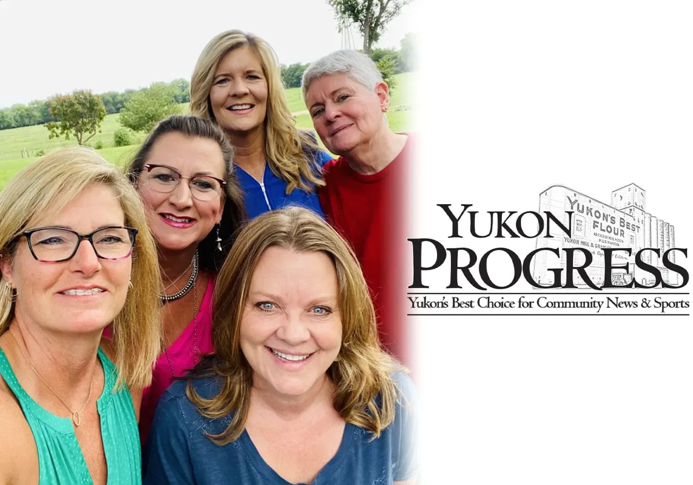 A group of women are posing for a picture in front of a yukon progress logo.