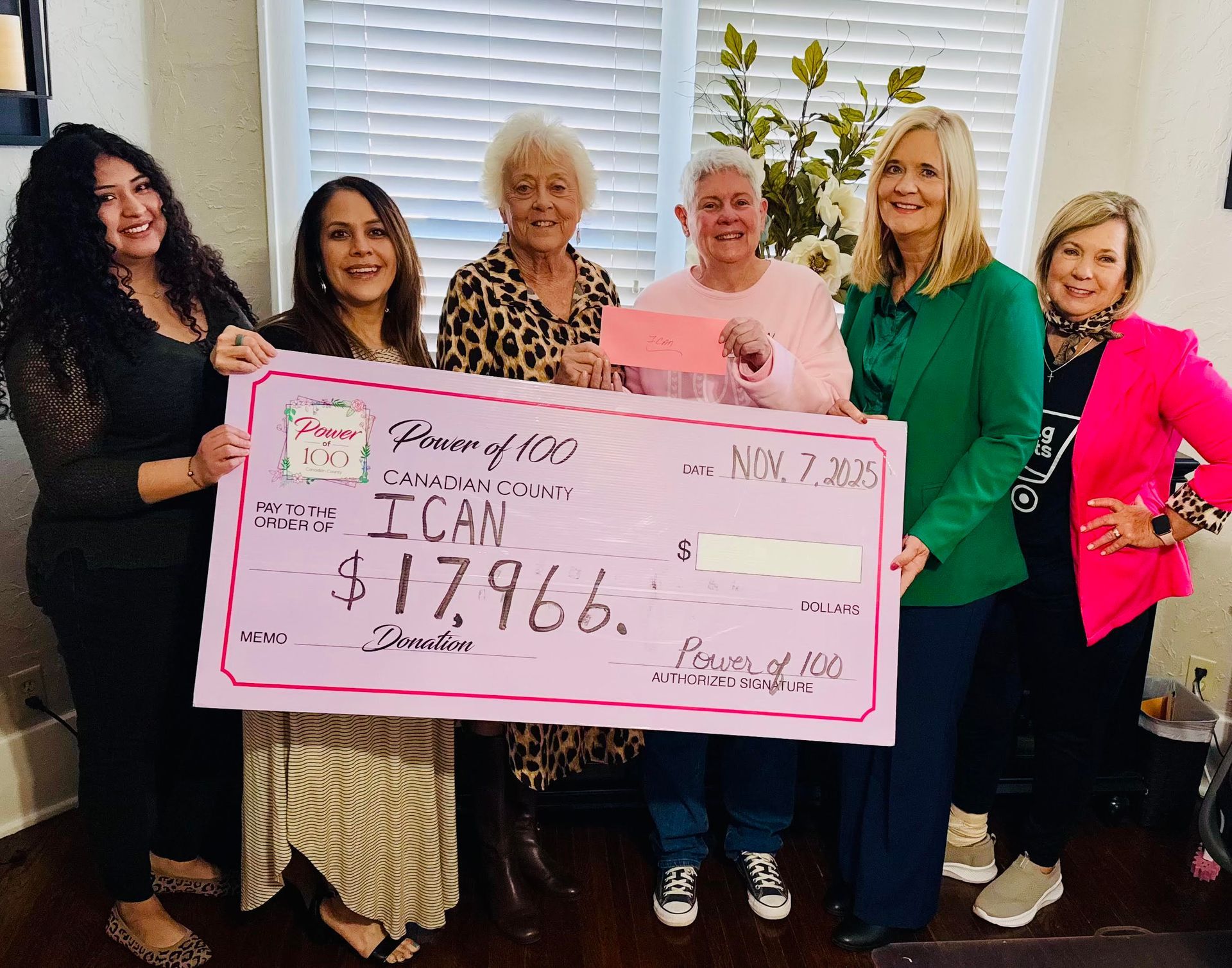 A group of people holding a check in front of jacob 's cupboard