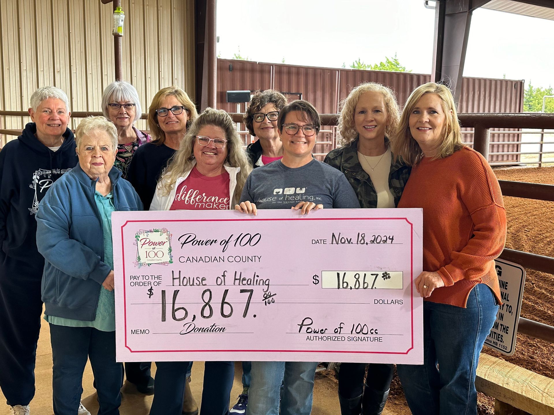 A group of people holding a check in front of jacob 's cupboard
