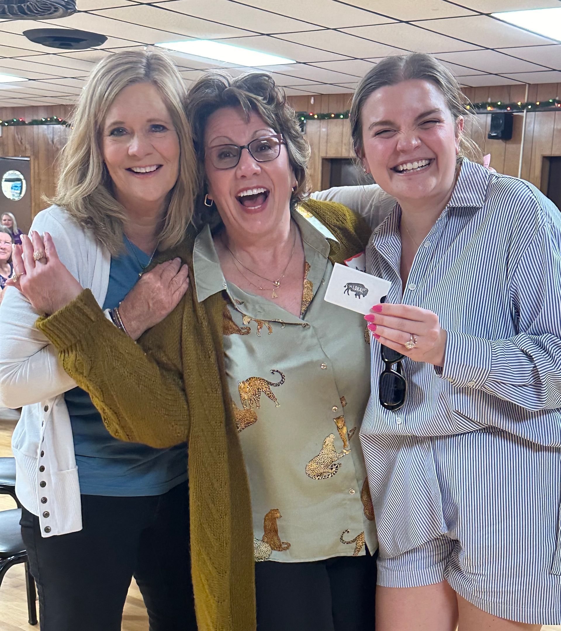 Three women are posing for a picture together in a room.