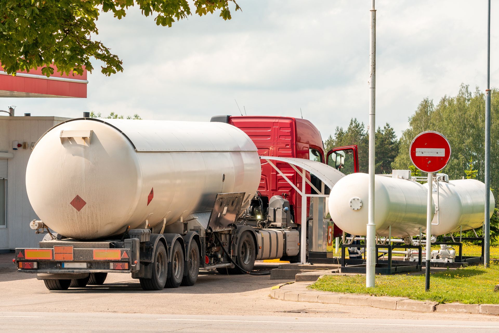 A tanker truck transporting a large gas tank for fuel delivery.