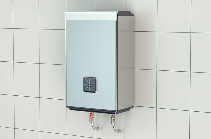 Silver electric water heater on a tiled wall; with digital display and water pipes.