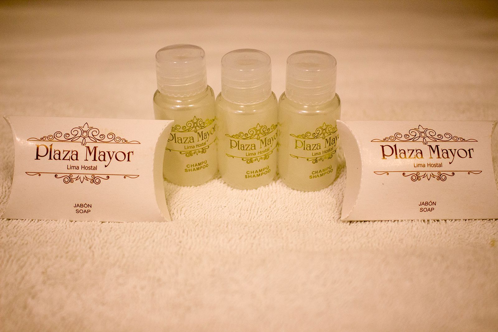 Three small shampoo bottles and two soap bars labeled 