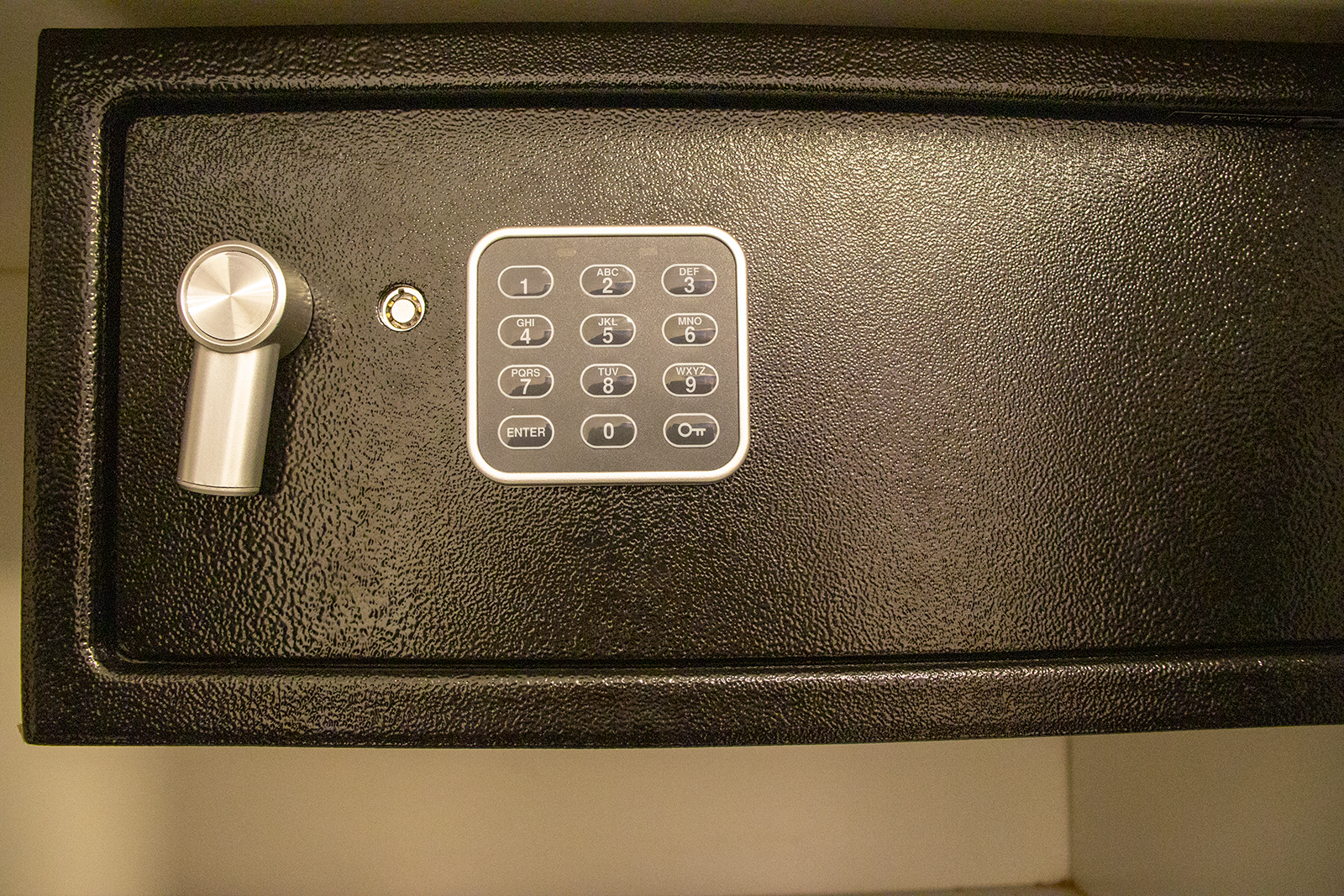 Black safe door with a keypad and a lock.