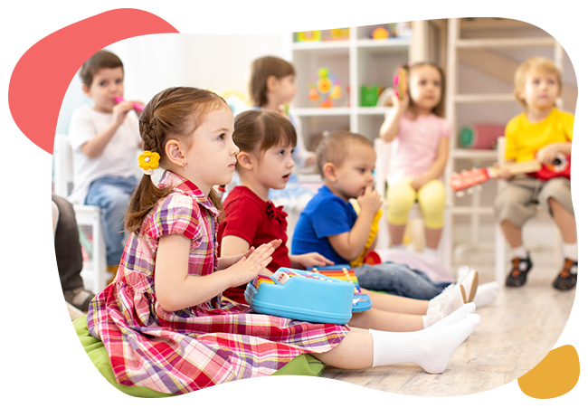 A group of children are sitting on the floor playing musical instruments.