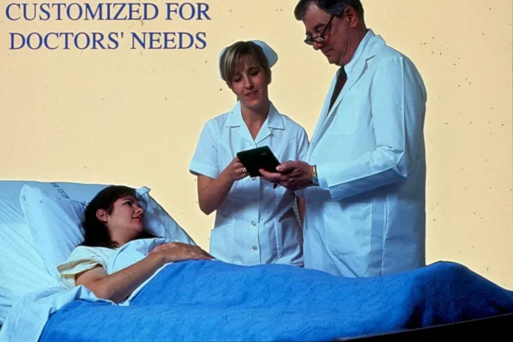 A woman in a hospital bed with two doctors standing around her