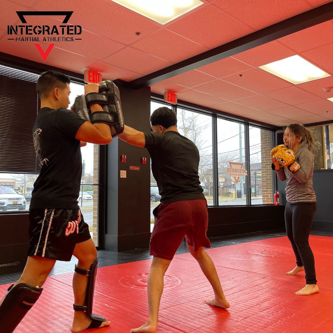 Two men are boxing in a gym with integrated written on the ceiling
