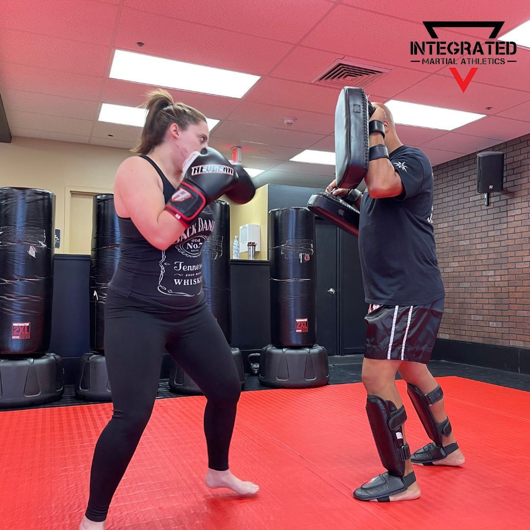 A man and a woman are boxing in a gym sponsored by integrated