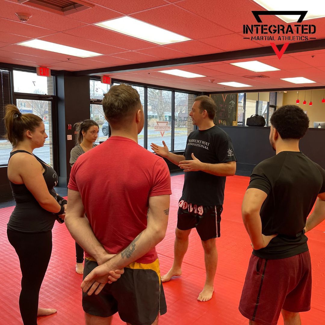 A group of people standing in a gym with integrated written on the ceiling