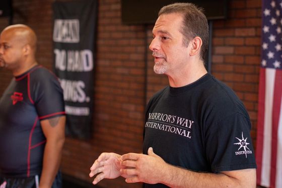 a man wearing a warrior 's way international shirt