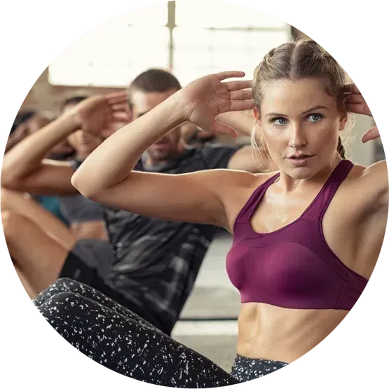 A group of people are doing sit ups in a gym.