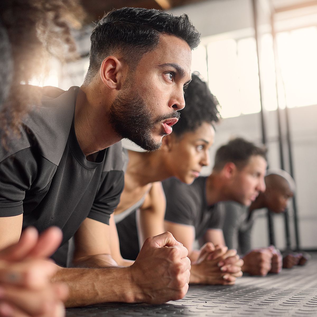 A group of people are doing push ups in a gym.