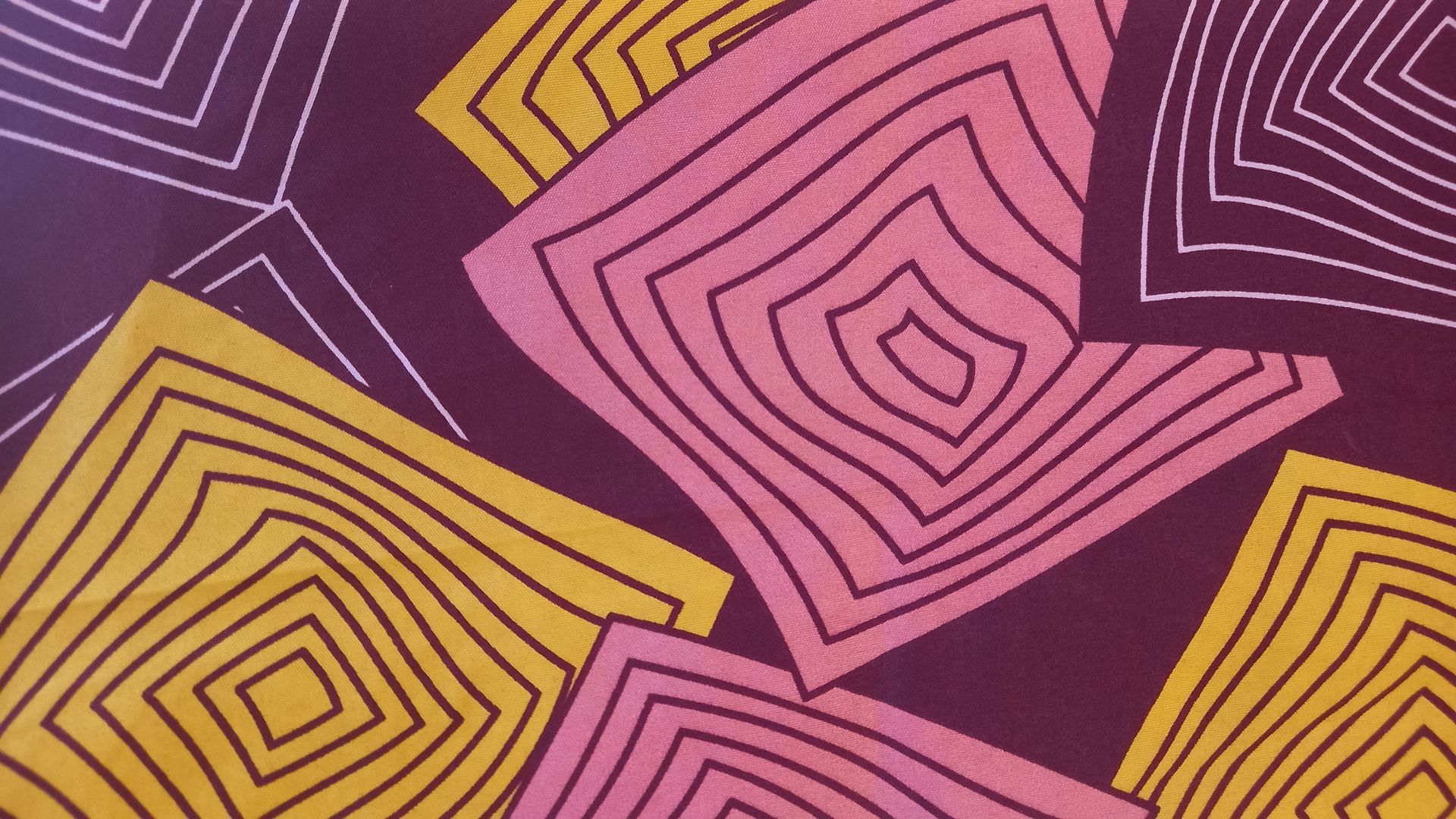 Um close de um padrão rosa e amarelo em um fundo roxo