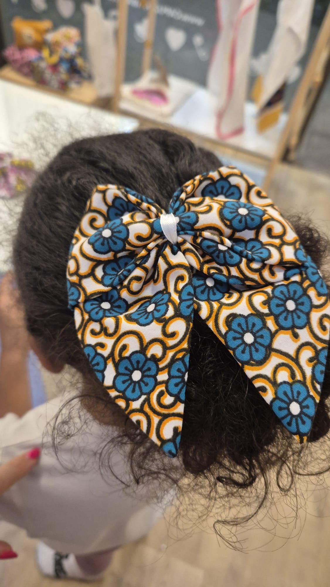 Uma garotinha está usando um laço no cabelo.