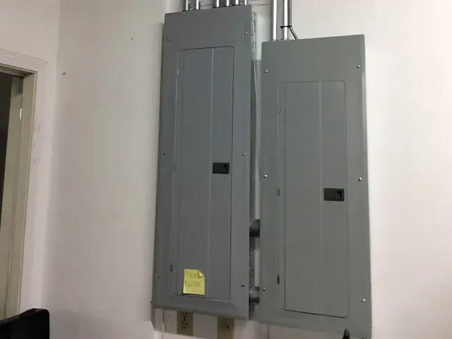 two electrical panels are hanging on a white wall .