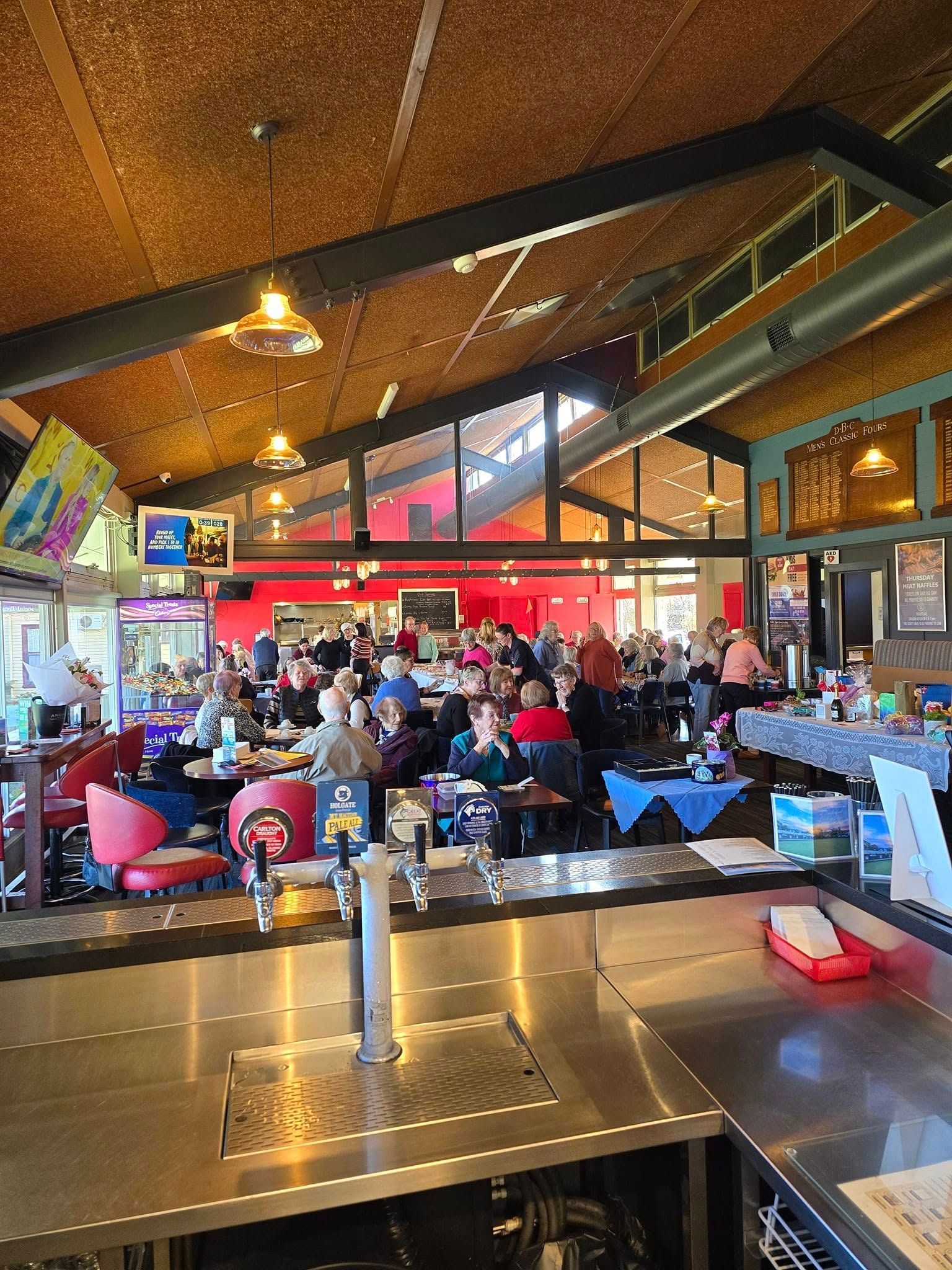 Inside venue with pitched roof and red wall.