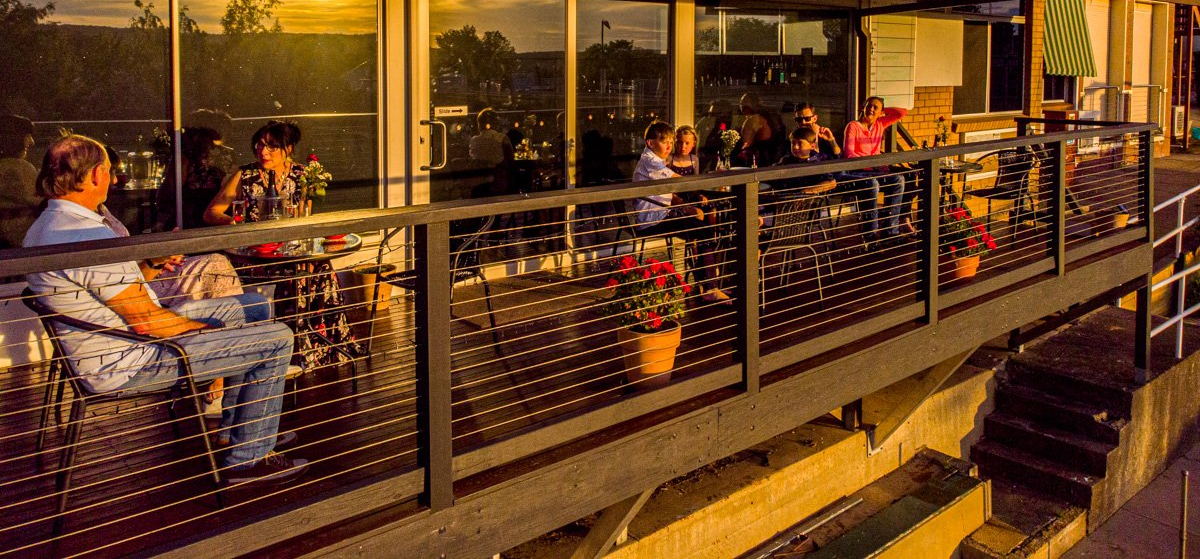 People on balcony of venue at sunset.