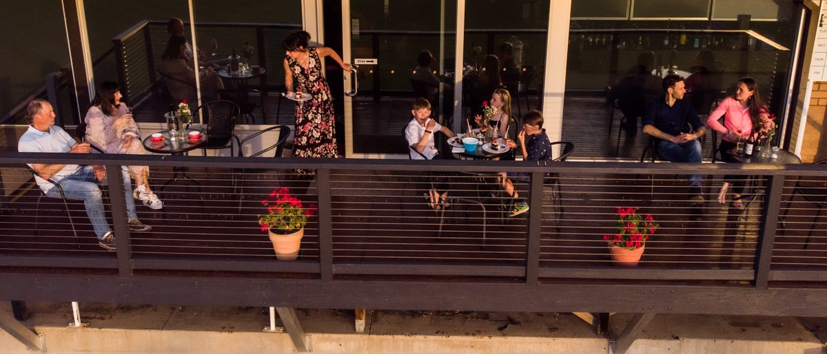 People on balcony of venue at sunset.