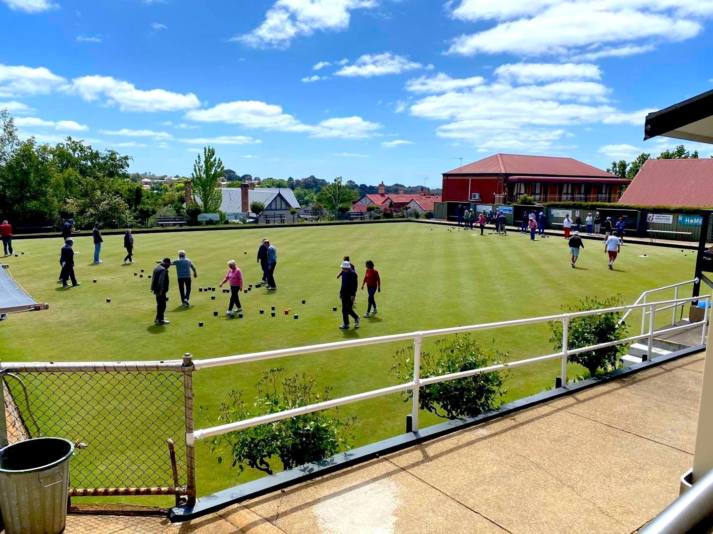 People playing lawn bowls on a cloudy day. 