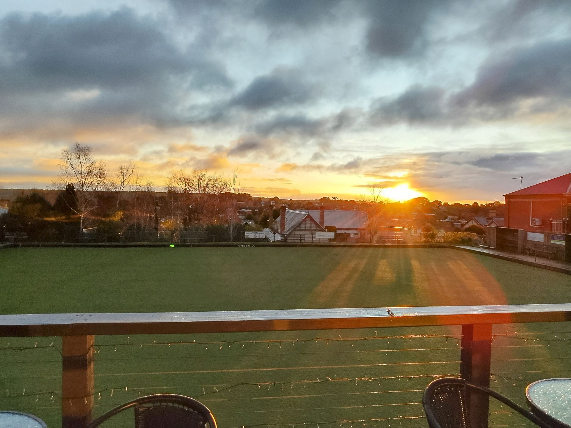 Sunset at bowling green with grey fluffy clouds.