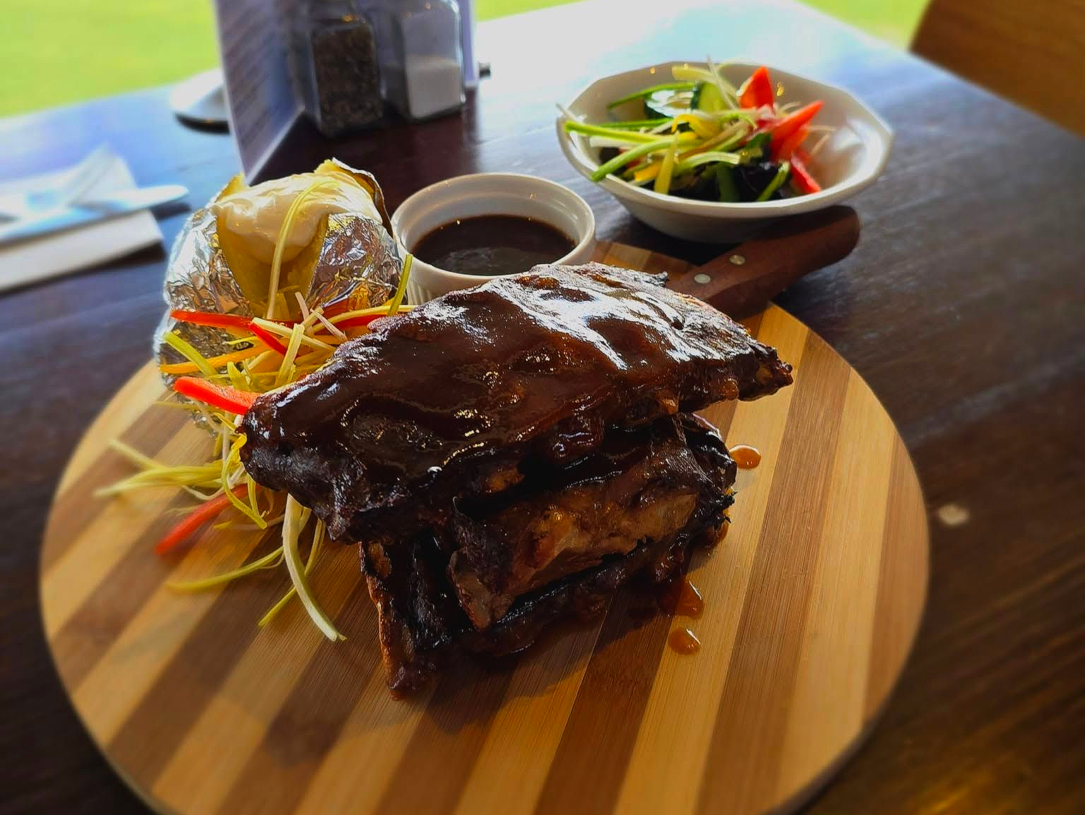 Steak and vegetables on wooden board.
