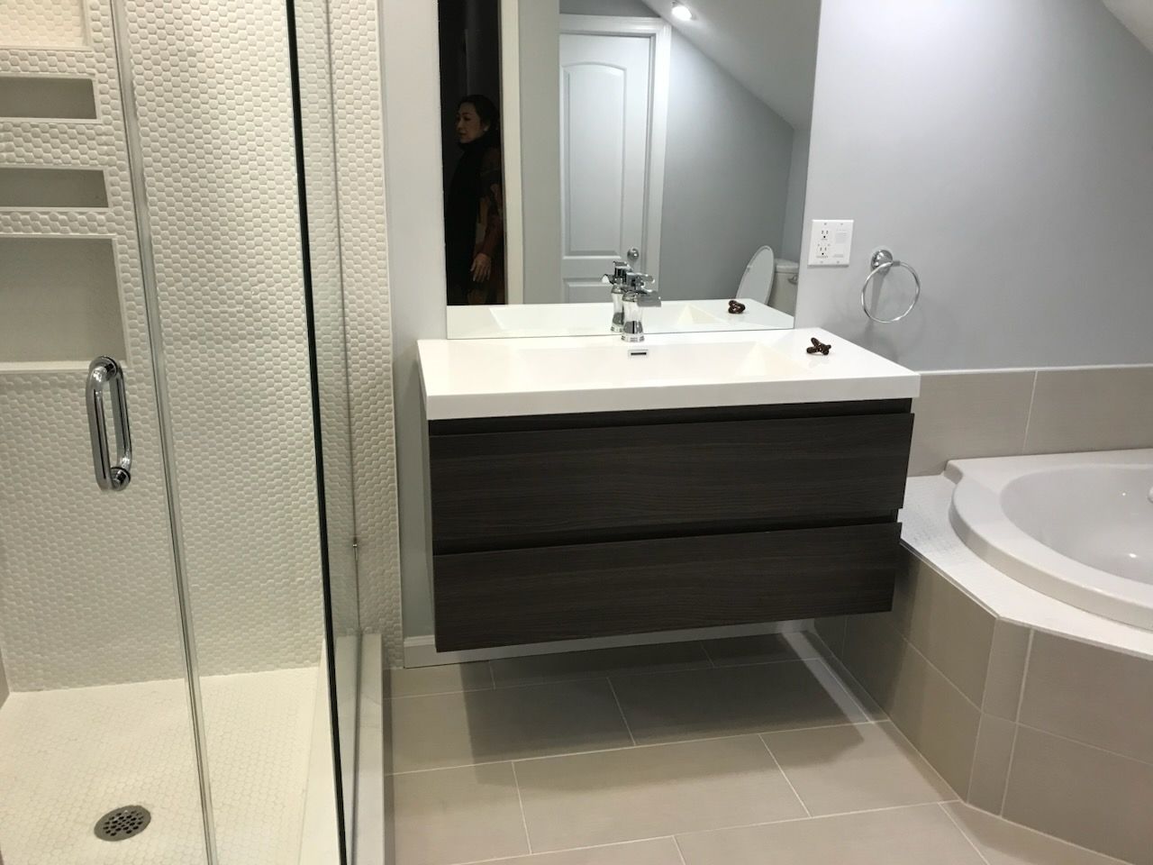 Bathroom with shower, vanity sink, and corner bathtub in neutral tones