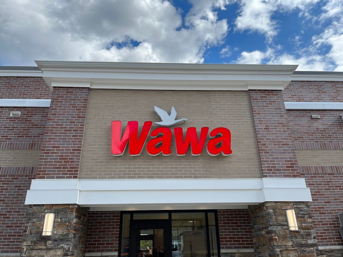 The front of a wawa store with a red sign and a white bird on it.