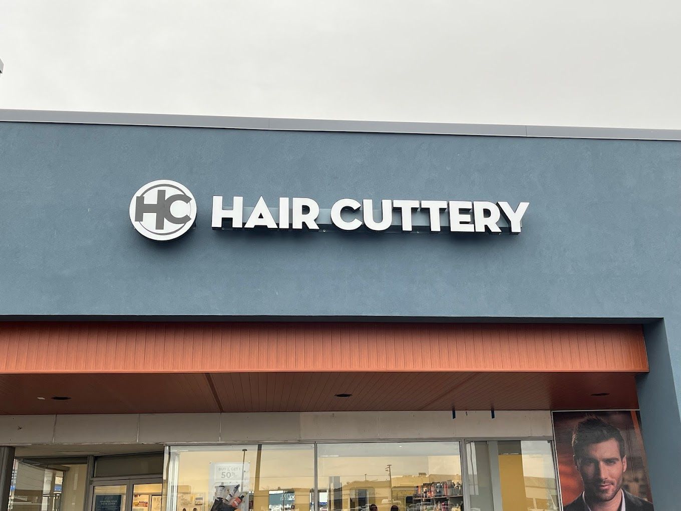 The front of a hair cuttery store with a sign above the door.